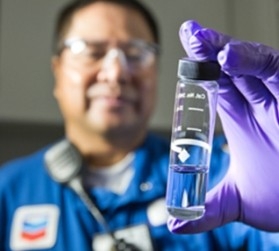 Person in lab holding glass container Person in lab holding glass container