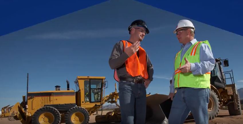 2 men with heavy equipment